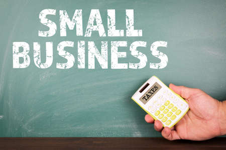 SMALL BUSINESS. Taxes, regulations and requirements concept. Calculator in male handsの写真素材