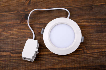 Led luminaire in white on a wooden texture backgroundの写真素材