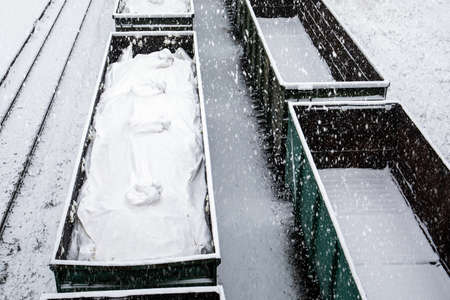 Snow covered freight train at the station. Snowfall, storm and frost