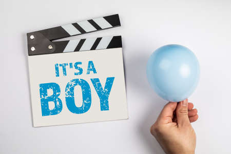 Its a boy. Birthday and sonographic examination concept. Movie clapper and a blue balloon on a white backgroundの写真素材