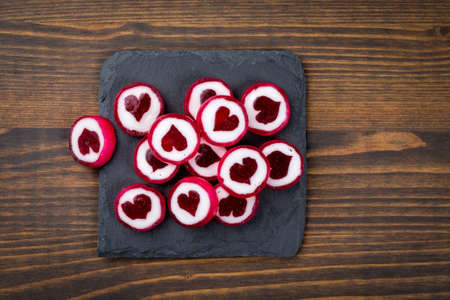 caramel candies in the form of hearts on a stone surfaceの写真素材