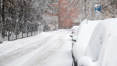 Parked cars covered with snow, snow storm. Slippery and dangerousの写真素材