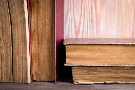 Stack of old antique books. Wooden shelf