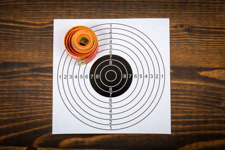 Weight loss and health concept. Tape measure and paper target on a wooden background