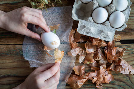Putting onion skin on white egg, egg coloring for Easter using materials of nature