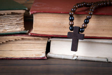 Stack of books and wooden cross. Religion, prejudice, prohibition and faith conceptの写真素材