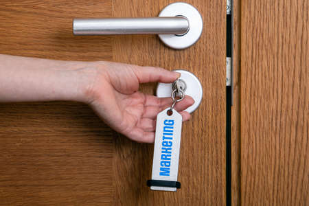 Marketing Concept. Unlocks the wooden door with a key