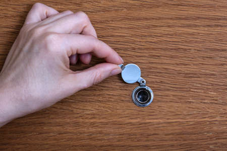 Female hand opens door peephole. Hotel doorの写真素材