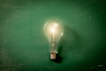 Light Bulb on a background of green chalk boardの写真素材