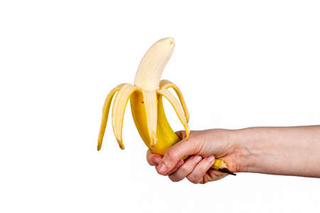 Peeled banana in a womans hand. White backgroundの写真素材