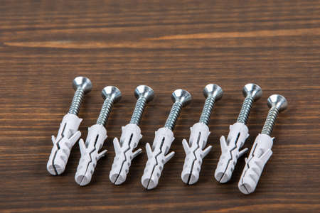 Screws with dowels on a wooden texture table