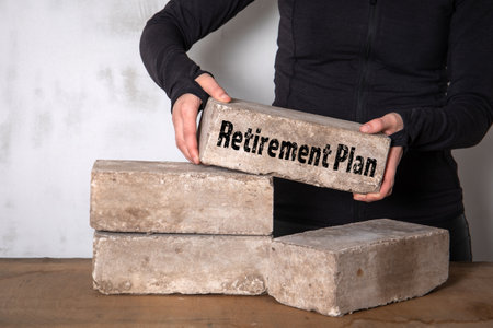Retirement Plan. Woman builds a pile of bricks on a wooden tableの写真素材