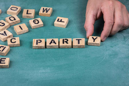 Party. Wooden alphabet letters on a green blackboard backgroundの写真素材