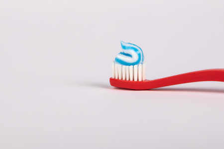 Toothpaste on a red toothbrush. Oral hygiene and health conceptの写真素材