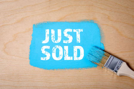 JUST SOLD. Paint brush with blue paint on a wooden surfaceの写真素材