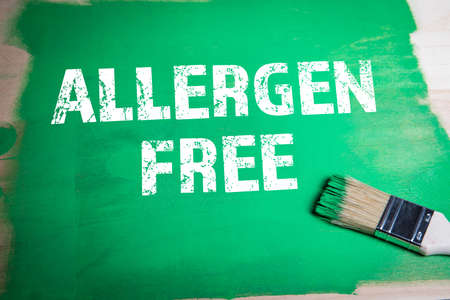 Allergen Free. Paint brush with green paint on a wooden surfaceの素材 [FY310169948369]