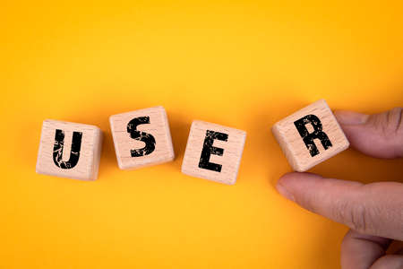 USER. Wooden cubes with text on a yellow backgroundの写真素材