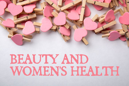 Beauty and women's health. Wooden pegs with pink hearts on a white background.の写真素材