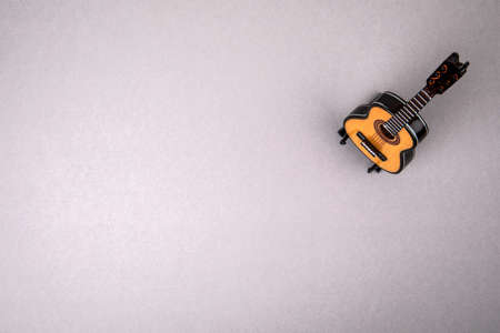 Mini acoustic guitar on a gray background. Free space for text and advertising.の写真素材