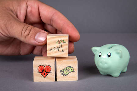 Retirement planning concept. Piggy bank and wooden blocks on a gray background