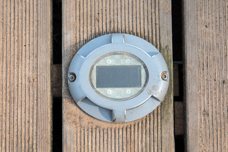 Led lamp and solar panel on a wooden footpath on the beachの写真素材
