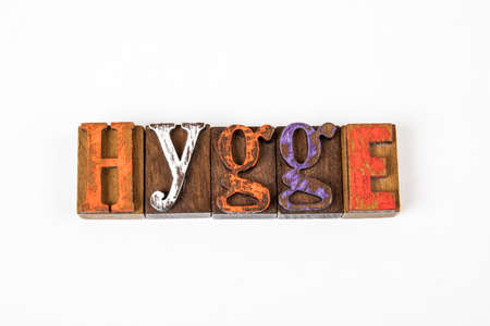 HYGGE, Danish lifestyle concept. Colored wooden alphabet letters on a white background