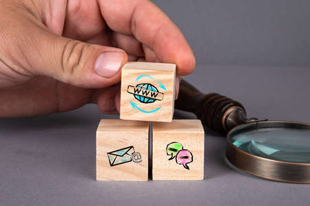 Digital Marketing concept. Magnifying glass and wooden blocks on a gray background