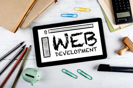 Web Development. Computer tablet, books and pencils on office deskの写真素材
