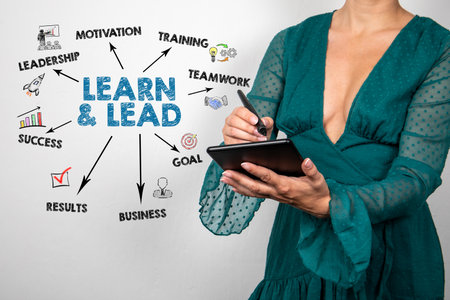 Learn and Lead concept. Tablet in woman hands. Beautiful green dressの写真素材