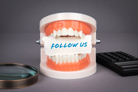 Follow Us. Magnifying glass and calculator on a gray backgroundの写真素材