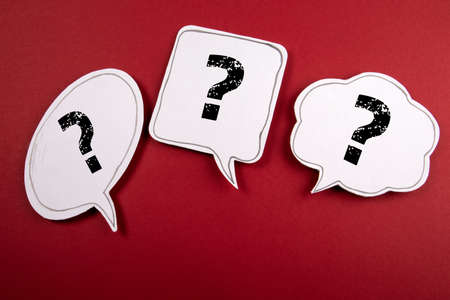Three speech bubbles with question marks on a red backgroundの写真素材