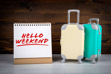 Hello Weekend. Two suitcases on a wooden table