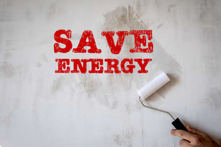 Save Energy. Painter paints a white wall