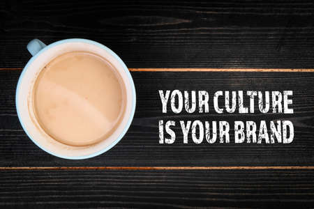 Your Culture Is Your Brand. Coffee mug on a dark wooden tableの写真素材