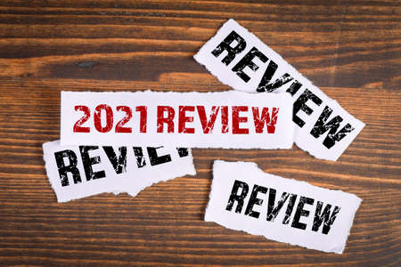 2021 review concept. White torn papers on a wooden backgroundの写真素材