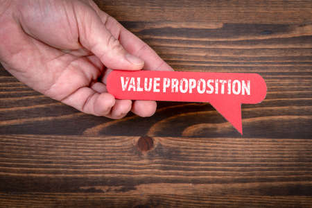 Value Proposition. Red speech bubble on a wooden background
