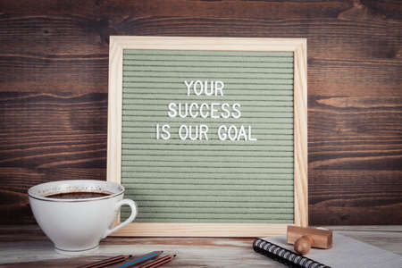 Your Success is our Goal. English text on a letter Board. Stationery on a wooden tableの写真素材