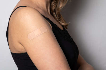 Vaccination on a womans shoulder. Medical patch on the skin