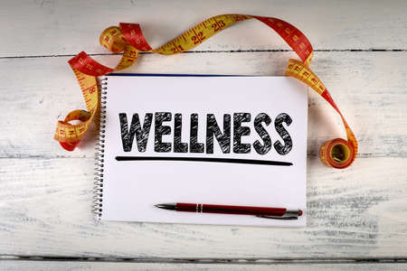 Wellness. Measuring tape, pen and notebook on a wooden tableの写真素材
