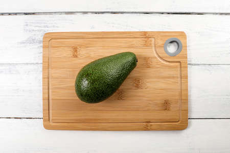 Avocado fruit on a bamboo cutting board. Diet and healthy lifestyle