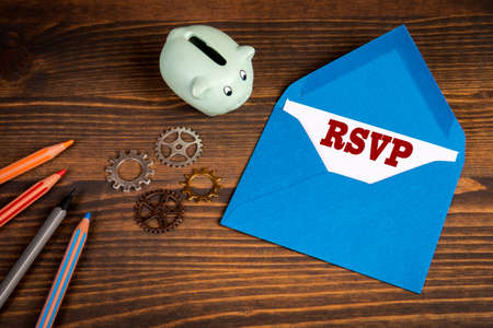 Please respond letter concept. Piggy bank, colored pencils on a wooden tableの写真素材