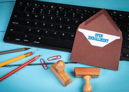 Open Enrollment. Brown letter envelope on black computer keyboard