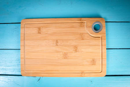 Bamboo cutting board on a blue wooden backgroundの写真素材