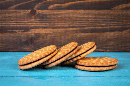 Cookies stacked with chocolate filling. Holidays and celebrations. Wooden background