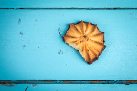 Bitten cookie on a background of blue wood texture