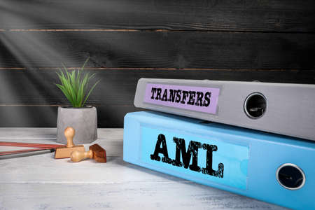 Transfers and AML Anti Money Laundering. Document binders on the office desk