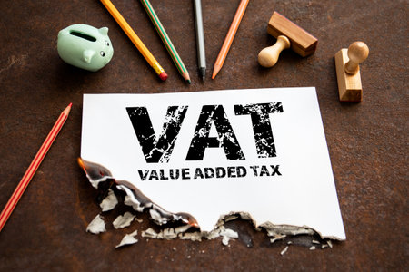 VALUE ADDED TAX. Piggy bank and office supplies on a rusty metal backgroundの写真素材