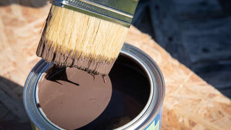 Paintbrush in the can of brown paintの写真素材