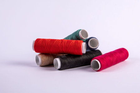 Thread spools in different colors on a white background