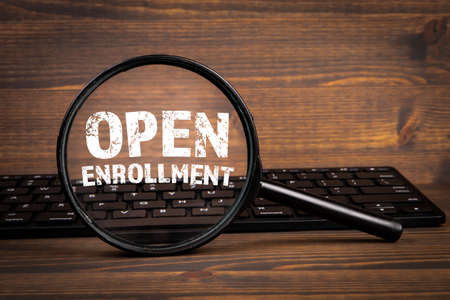 Open Enrollment. Search, Research and Registration concept. Magnifying glass and computer keyboardの写真素材